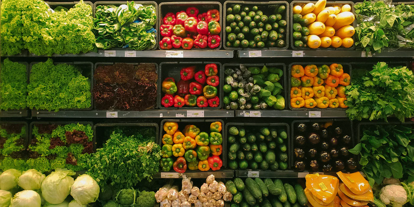 Supermarket produce shelves stocked with vegetables